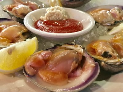 Fresh oysters on ice with lemon wedges and cocktail sauce, perfect seafood appetizer.